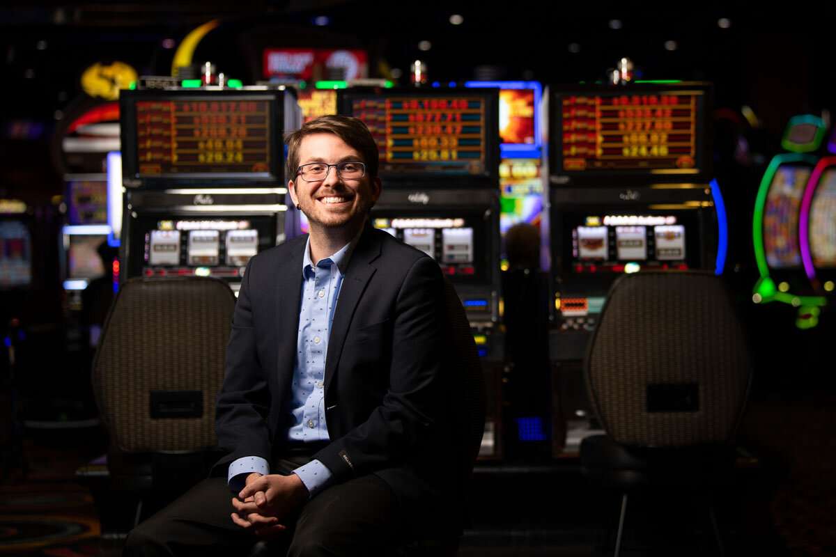Staff member seated in front of slot machines. © robert lowdon