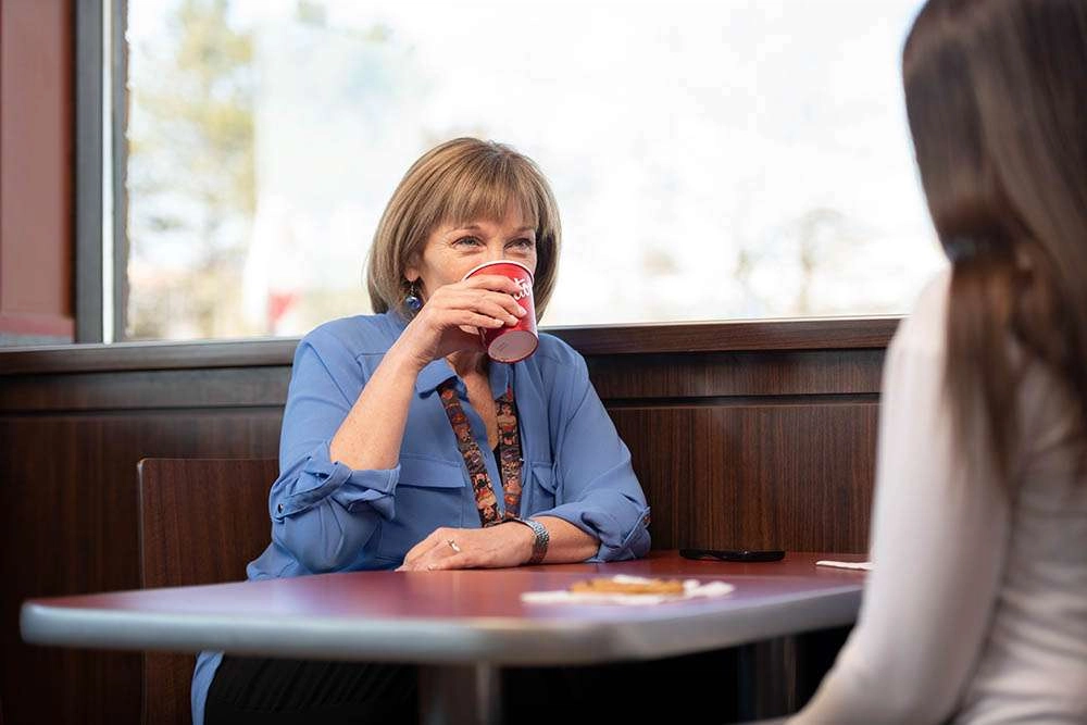 A employee of yssn drinks coffee with a client. © robert lowdon