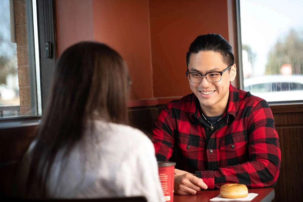 A conversation over coffee and doughnuts. © robert lowdon