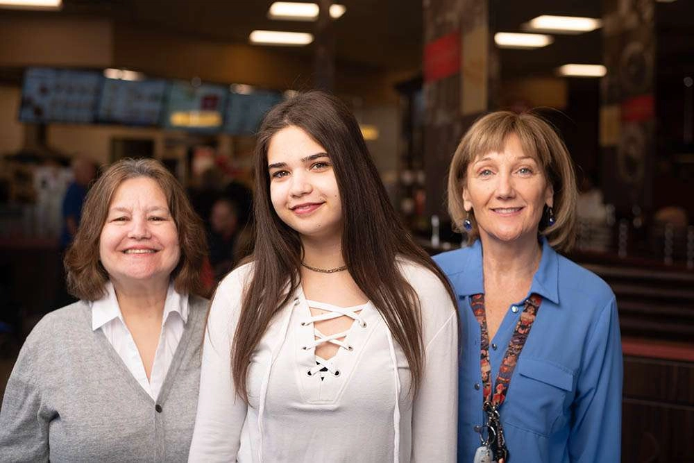 Three stand together at the coffee shop. © robert lowdon