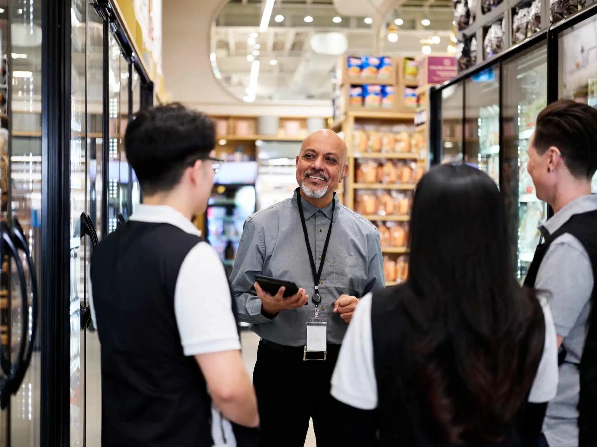 Grocery store supervisor training new team members.