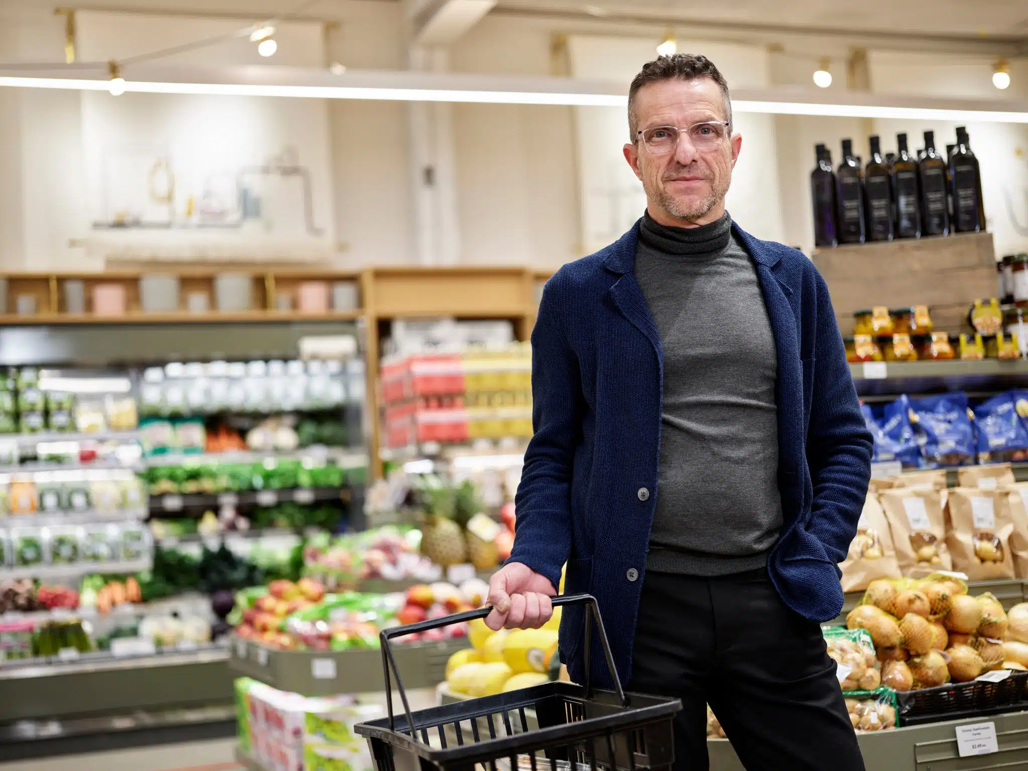 Grocery store customer shopping in produce aisle.