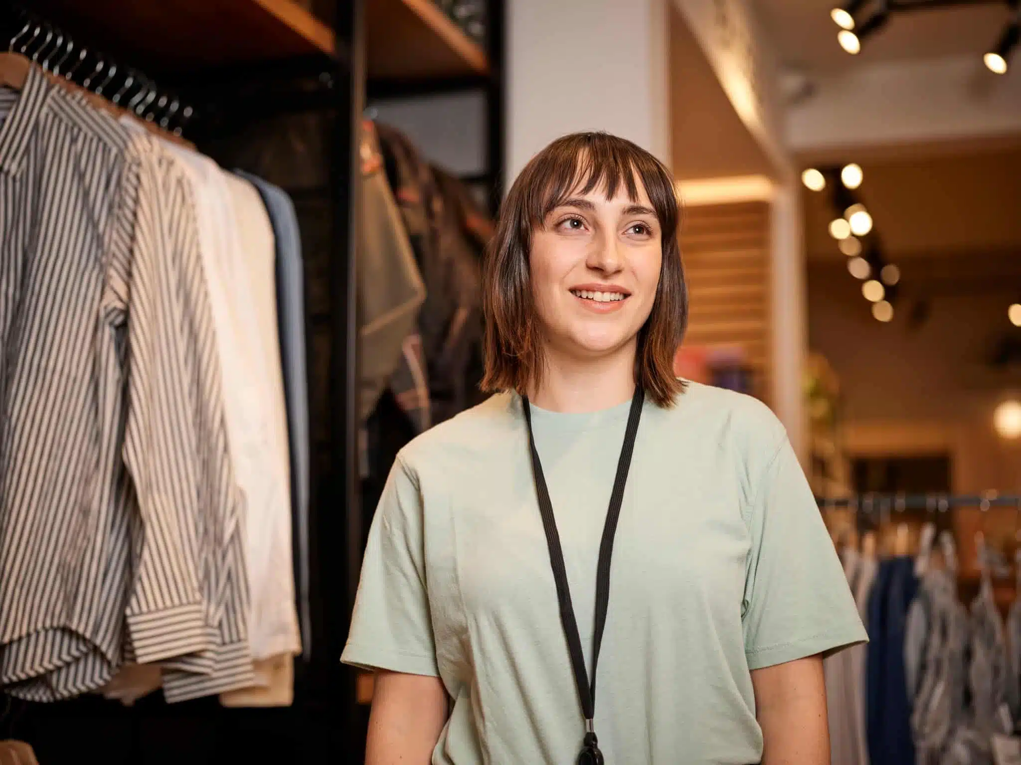 Retail store employee in men's clothing section.