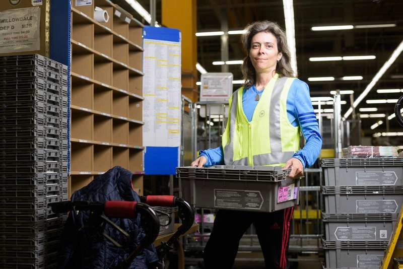A worker sorts mail at her station.