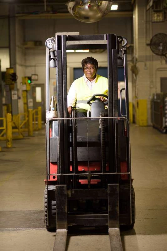 Lady drives forklift on dock