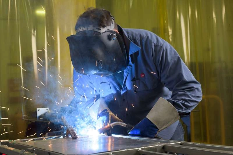 A mechanic welds a cart in the machine shop of a canada post facility. Getting these welding shots is tricky because you can’t really look through the view finder without damaging your eyes. There is quite a bit of guess work with these types of ind…