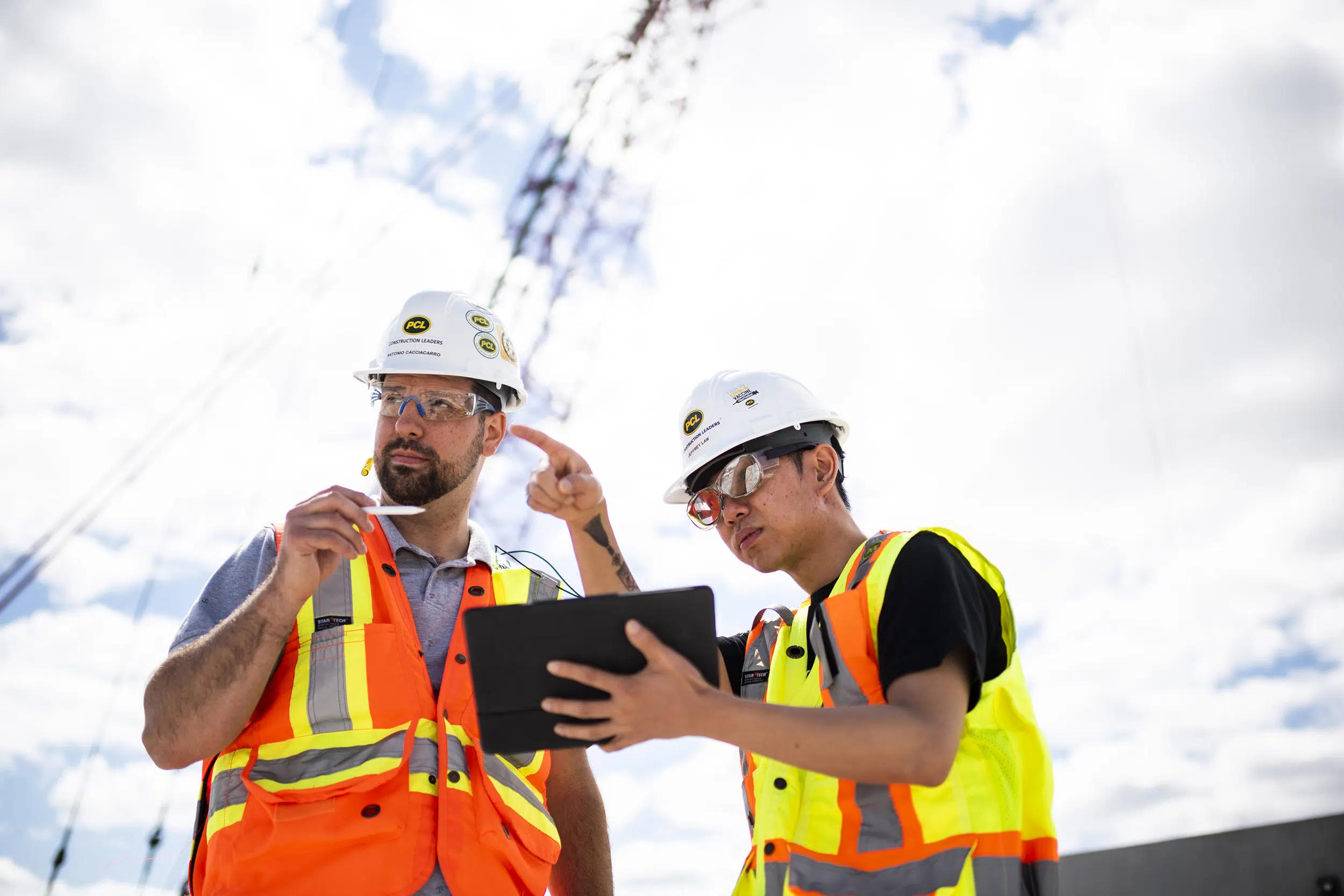 Two workers use teamwork to discuss possible issues on a jobsite.