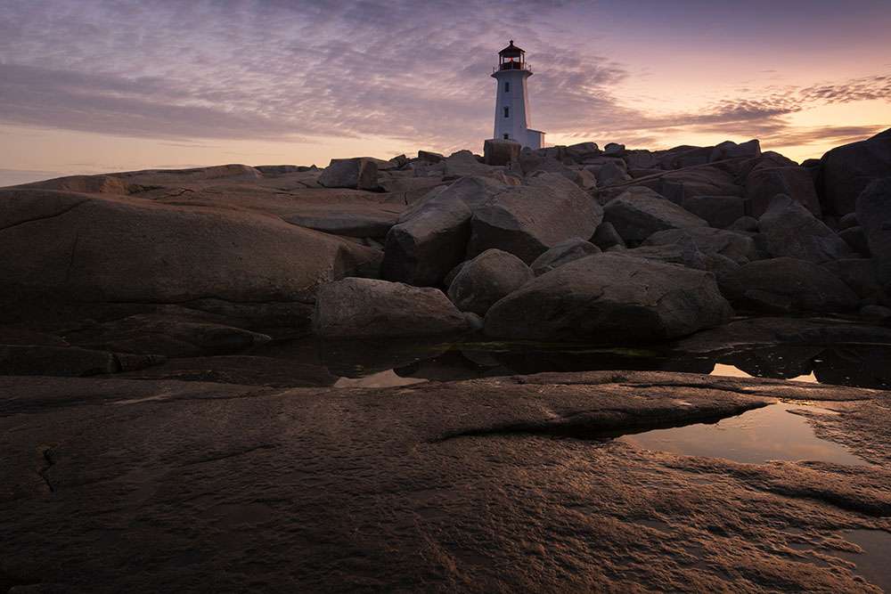 The rocks reflect the rising sun at peggys cove. © robert lowdon