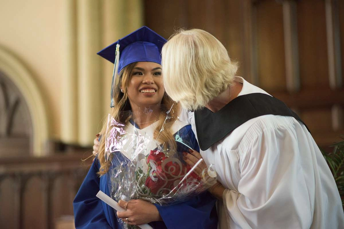 Editorial Photography For Cdi College - Editorial Photgrapher Robert Lowdon Cdi 18 A smiling student is congratulated by her instructor. Both are dressed in academic regalia. A shallow depth of field is used to draw the eye to the student’s smiling face in this celebratory moment.