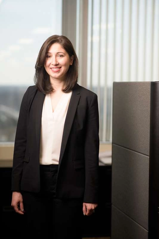 A business executive stands next to an office cubicle. ©Robert Lowdon