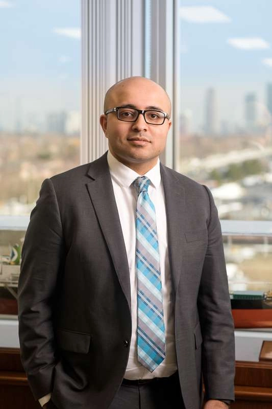 A business executive stands next to a window. © robert lowdon