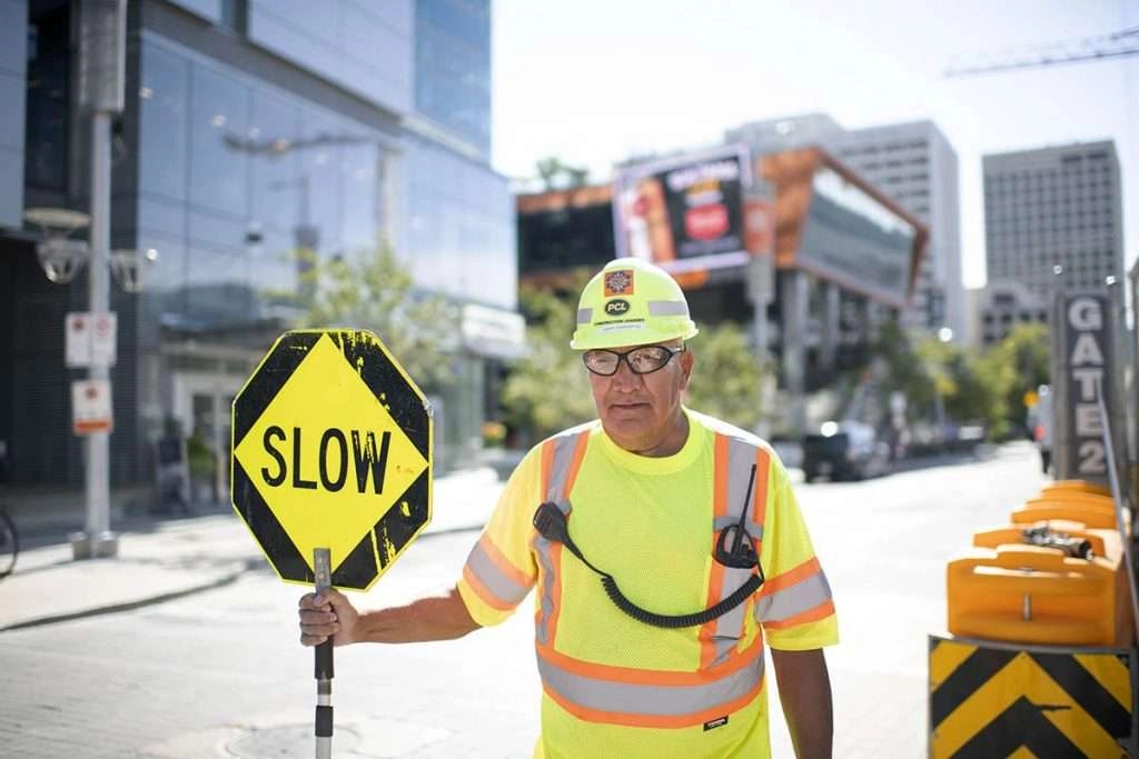 Flag man holds sign 