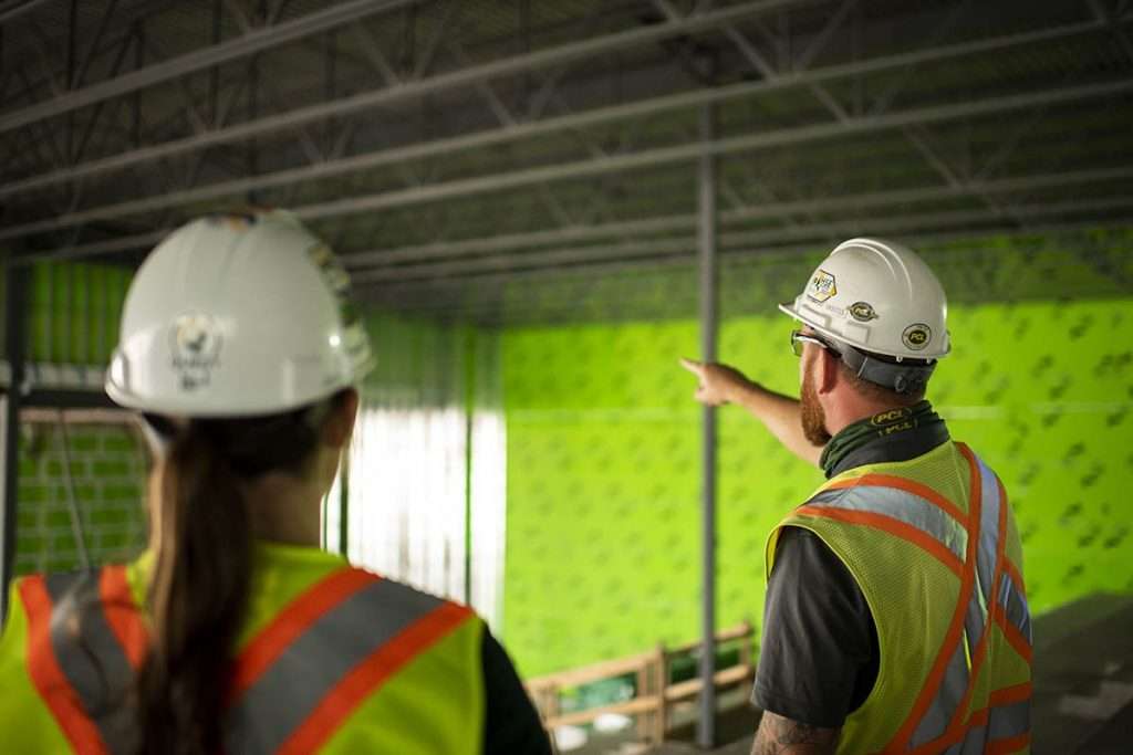 A construction foreman discusses a building project with a co-worker.  