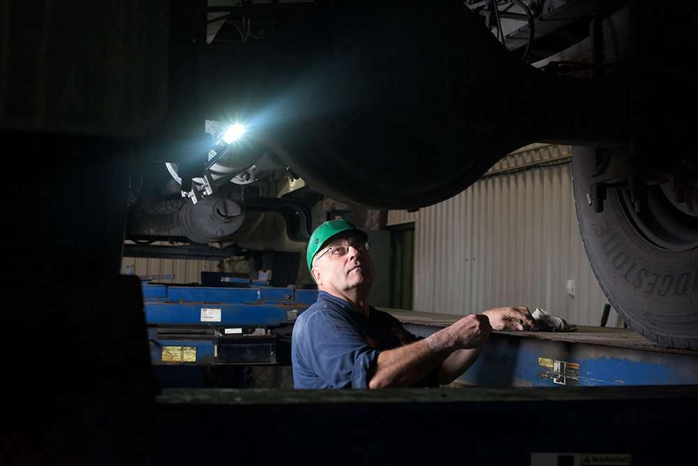 mechanic under truck with light