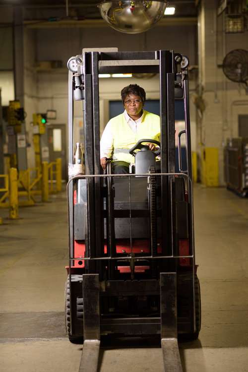 female worker drives forklift