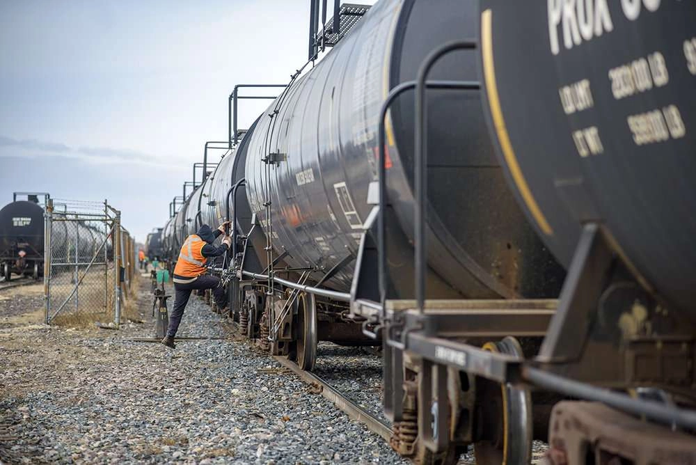 worker inspects rail cars