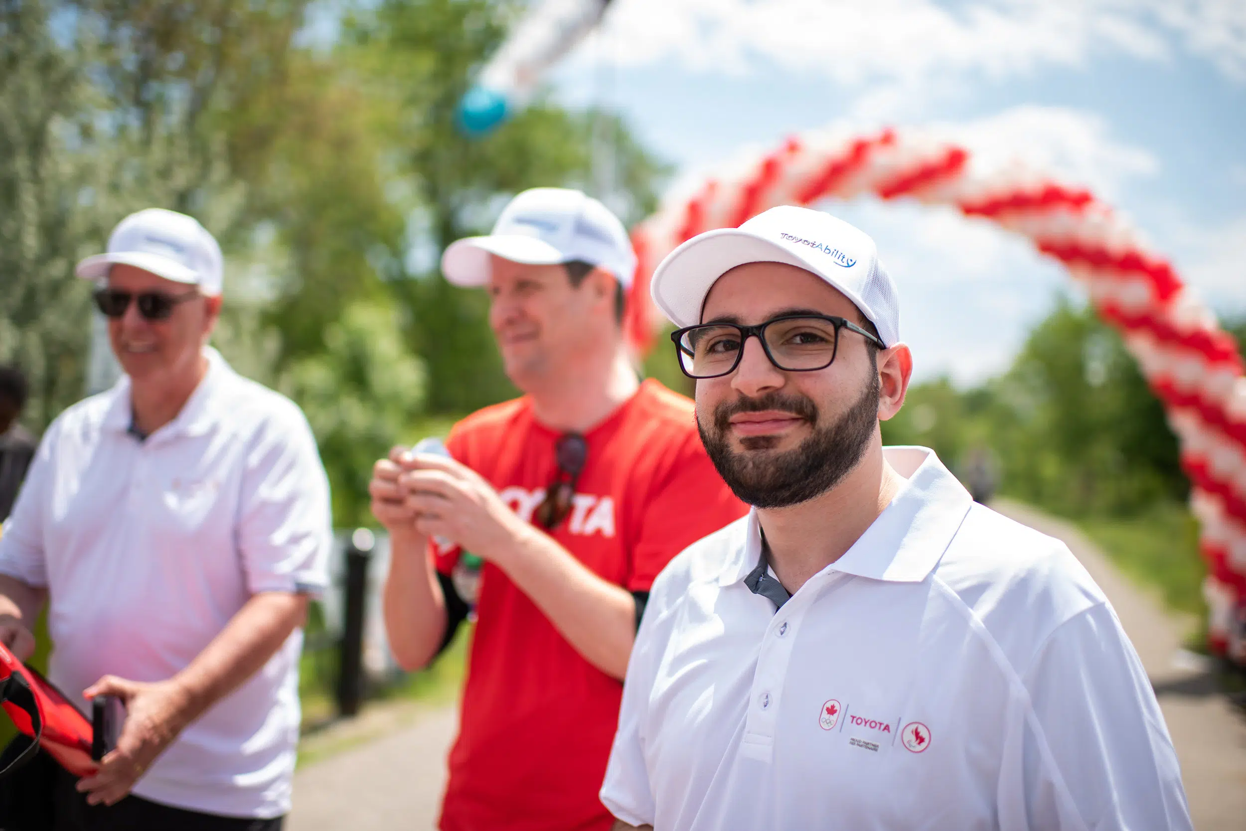 A male participant at an event in a group. He wears a toyota shirt.